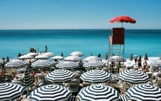 Black and white striped beach umbrellas on the French Riviera in Nice, France.